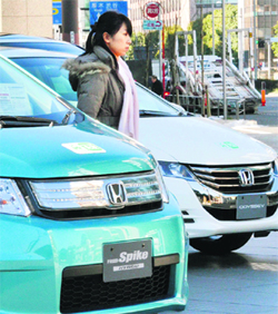 A customer checks out vehicles from Japanese auto giant Honda Motor at the company's showroom in Tokyo on Tuesday. Honda said its net profit in the nine months to December slumped 71.4 per cent from the previous year due to Japan's March disasters, huge floods in Thailand, and the high yen. 