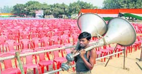 A worker of an event management company gathers goods after a political rally during the campaign period