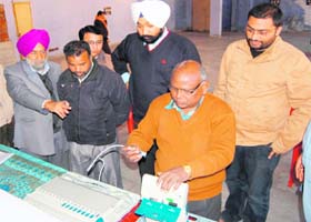 An expert feeds data in new EVMs for the re-poll process of Booth No 76 of the Amritsar (East) constituency in the presence of candidates and their representatives at Mai Bhago Polytechnic College in Amritsar