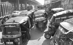 Three-wheelers parked on the pavement under the Zirakpur flyover