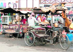 People eat at unhygienic eateries near the bus stand in Amritsar