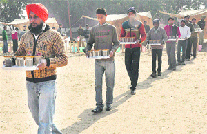Candidates carry glasses of water during a selection process at the Police Lines, Sector 26, Chandigarh on Thursday. 