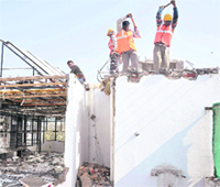 Workers with the municipal corporation demolish the part of a hotel at Attawa in Sector 42 of Chandigarh on Thursday. 