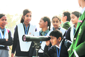 Schoolchildren watch migratory birds at Asan Barrage during the World Wetlands Day celebrations on Thursday.