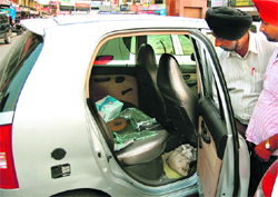 A man inspects his car after finding its windowpane broken and valuables lying in it missing in Amritsar.