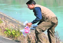 Rajaji National Park employee Ashish Gaur cleans the garbage alongside the Ganga canal in the Chilla range, Pauri Garhwal