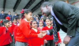 Guy P Djoken, executive director, UNESCO Centre for Peace, shakes hands with a student in Dehradun