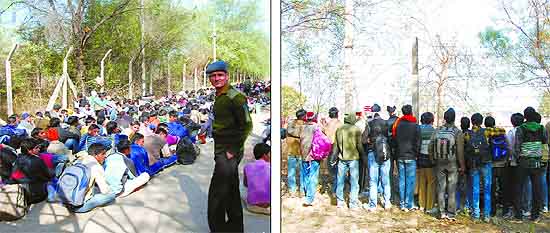 An Army man keeps watch as aspirants line up during the Army recruitment rally at the Bathinda cantonment; Curious onlookers gaze at the proceedings from behind the barbed wire fencing. The recruitment process, that is on till February 7, has seen a large number of candidates eager to don the battle fatigues