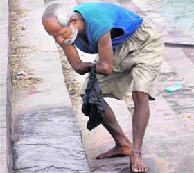 A physically challenged man cleans a Ganga ghat at Rodi Belwala in Haridwar