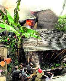 Fire fighters try to douse the fire that broke out due to an LPG cylinder blast in Tezpur, Assam, on Sunday