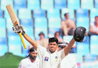 Pakistans Azhar Ali raises his bat to the crowd after scoring a century during the third day of the third Test against England in Dubai on Sunday.