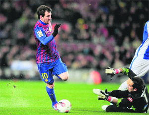 Barcelona's Lionel Messi (L) vies with Real Sociedad's goalkeeper Claudio Bravo during the Spanish league match in Barcelona on Saturday.  AFP 