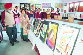 Government Girls Senior Secondary School Principal Sewa Singh Sekhon and head of the Fine Arts Department Mala Chawla look at paintings during the annual art work exhibition in Amritsar on Monday