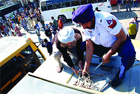 Bathinda traffic police officials remove a pressure horn kit installed on the rooftop of a bus during a special drive organised in the city. 