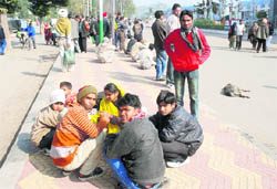A group of migrant labourers basks in the sun outside the railway station in Chandigarh