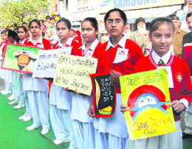 Schoolgirls form a human chain to fight female foeticide at Ram Nagar in Karnal on Monday.
