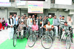 Four physically challenged persons who were given tricycles by the Nar Narain Sewa Samiti with samiti members at a camp on the premises of Shri Shiv Mandir Dharamshala, Shahabad Markanda.
