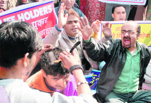 Kashmiri migrants tonsure their heads to protest against the apathetic attitude of the government towards their demands in Jammu on Monday.