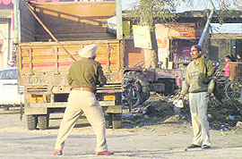 A policeman lathicharges an agitating worker of a distillery