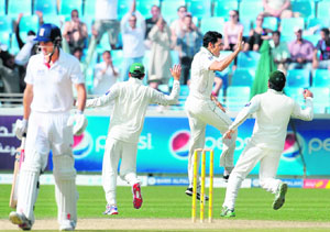 Pakistan's Umar Gul (2R) celebrates with teammates after claiming a wicket in the final Test against England in Dubai on Monday.
