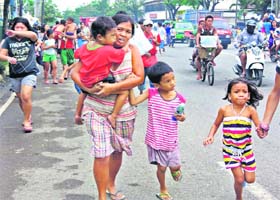 RUNNING FOR SAFETY: Residents head for high-altitude areas following tsunami rumours after an earthquake that hit the island province of Cebu on Monday