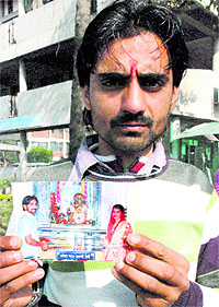 Narinder shows a photograph of his wedding, at the mini-secretariat in Panchkula on Monday