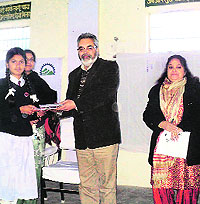 Satish Gupta DFO, Wildlife, gives away a prize to the winner of a contest on World Wetland Day at Nagrota Surian