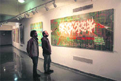 Visitors look at a painting during a workshop at the University of Jammu