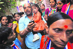 Jyoti Amge, the worlds shortest living woman, is carried by a supporter of the Maharashtra Navnirman Sena as she campaigns for the municipal elections in Mumbai on Tuesday. 