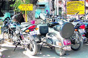 Sign boards at designated parking lots specify the hiked parking fee for two-wheelers and cars, which is more than the prescirbed parking charges