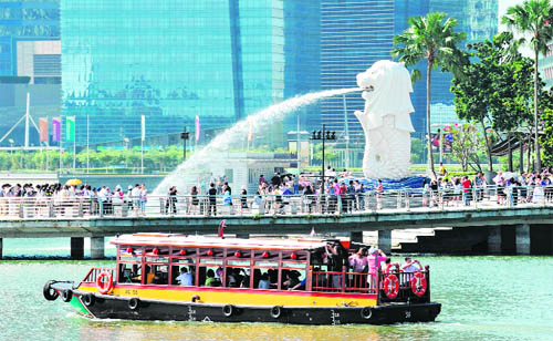 Tourists gather in front of the iconic statue of the Merlion in Singapore on Wednesday. The tiny Southeast Asian republic welcomed a record 13 million overseas visitors in 2010, the majority arriving from Asia, official data posted on February 7 showed.