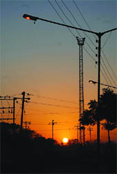 Streetlights are switched on even as the sun sets in the horizon near Santpura road on Wednesday.