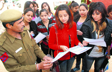 A policeman distributes literature on traffic rules among students of MCMDAV College, Sector 36, Chandigarh, on Wednesday.