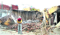 An illegal under-construction building being demolished by an MC team at Model Town in Jalandhar on Wednesday. 
