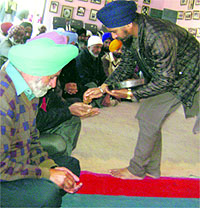Office-bearers of Grewal Sports Association partake karah after prayers at Grewal Stadium, Kila Raipur, on Wednesday