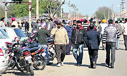 People wait at the office of the Sub-Registrar for the tehsildar and naib-tehsildar to arrive