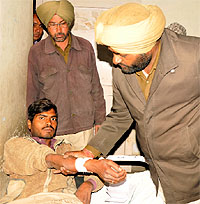 A cop checks the injured bus passenger at the Civil Hospital in Bathinda on Thursday
