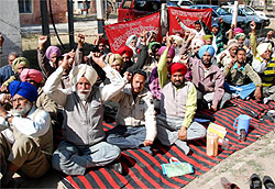 Members of the Sanjhi Taalmel Sangharsh Committee sit on a dharna in Bathinda on Thursday