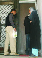 Neighbours gather outside the residence of Abida Begum, whose house was allegedly robbed by four men on Thursday.