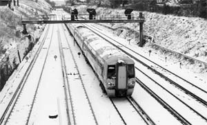 A train runs through snow-covered railway tracks in Croydon, South London.