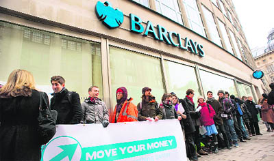 Customers queue up to close their bank accounts outside a Barclays Bank branch in central London on Friday. The protest was part of the "Move Your Money" campaign, the stated aims of which are to create a better banking system through consumer power. Barclays announced a 16% drop in annual net profits to 3.0 billion on falling revenues at its investment arm, and also announced a 25% cut in its bonus pool. 