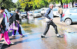 Residents pass through water at Sector 17 in Chandigarh on Friday