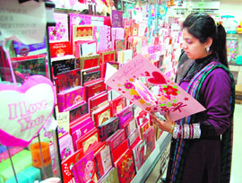 Looking for words to express love: A girl is busy looking at cards at a shop 
