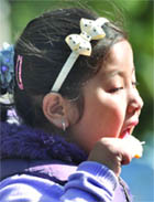 A girl enjoys icecream on a chilly day. 