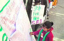 A child signs a poster during a signature campaign outside the DCs office in Shimla on Saturday. 