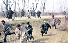 Kashmiri villagers run for cover during a clash with security forces at Lesar village in the Rafiabad area of Baramulla on Saturday. 