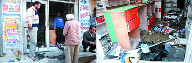 Police officials look for clues at the chemist shop on Ajit road that was ransacked by unidentified assailants on Sunday; a view of the ransacked chemist shop. 