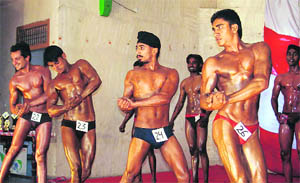 Bodybuilders exhibit their muscles during a competition organised by the District Bodybuilders Association at Fatehabad on Sunday. 