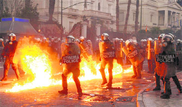 A petrol bomb explodes near riot police during a huge anti-austerity demonstration in Syntagma (Constitution) Square in downtown Athens on Sunday. Greek lawmakers looked set to endorse a new and deeply unpopular austerity deal to secure a multibillion euro bailout package and avert what Prime Minister Lucas Papademos warned would be economic chaos.