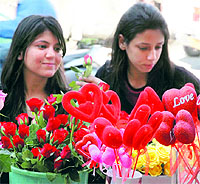 Girls admire flowers and gift items in a market